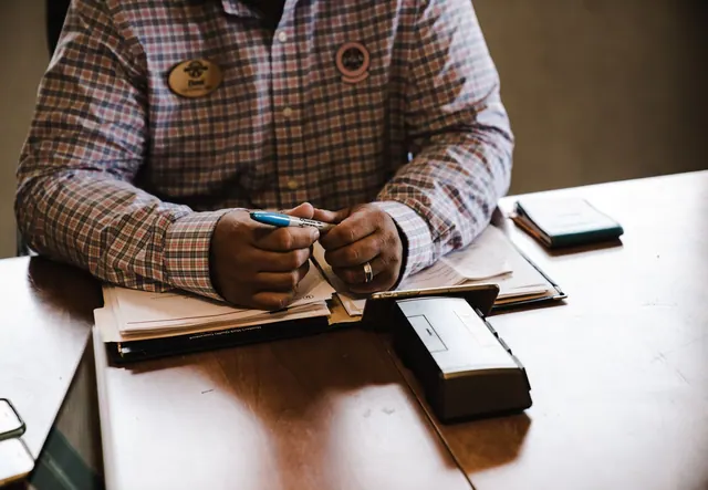 A businessman with documents, organizing and working at his desk for an office task. Grant alerts: review checklist and 2027 updates