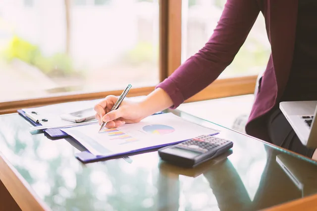 Hand business woman pointing paper data analyze chart on desk at office room.young girl writing into her diary about recipient address on mailing envelope,female hands sending letter,business concept. Grants for women: four structures, scam signs, and where to verify listings