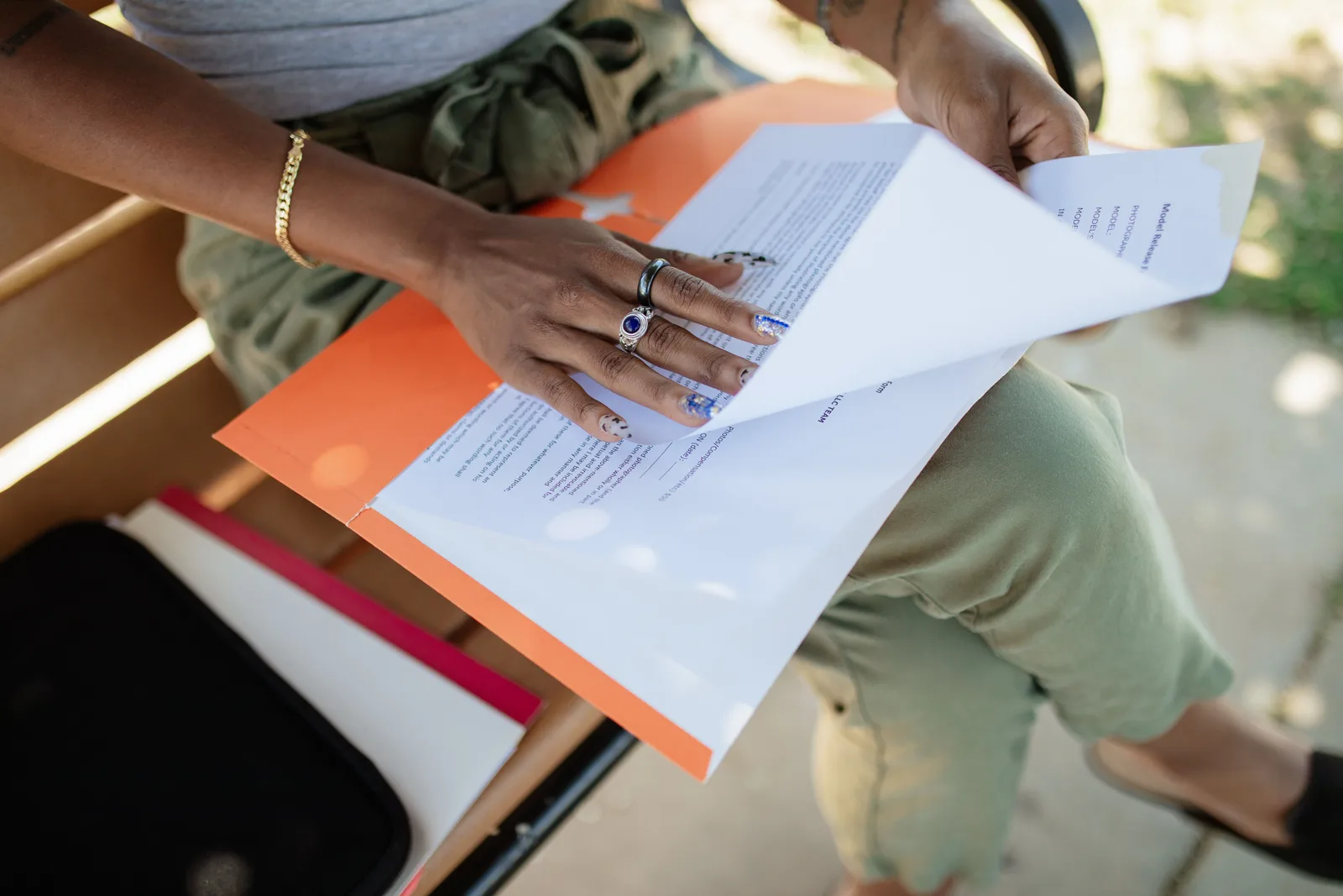 Close-up of a woman checking documents on a bench in natural light. Industry grant mistakes: four notice terms that decide the outcome